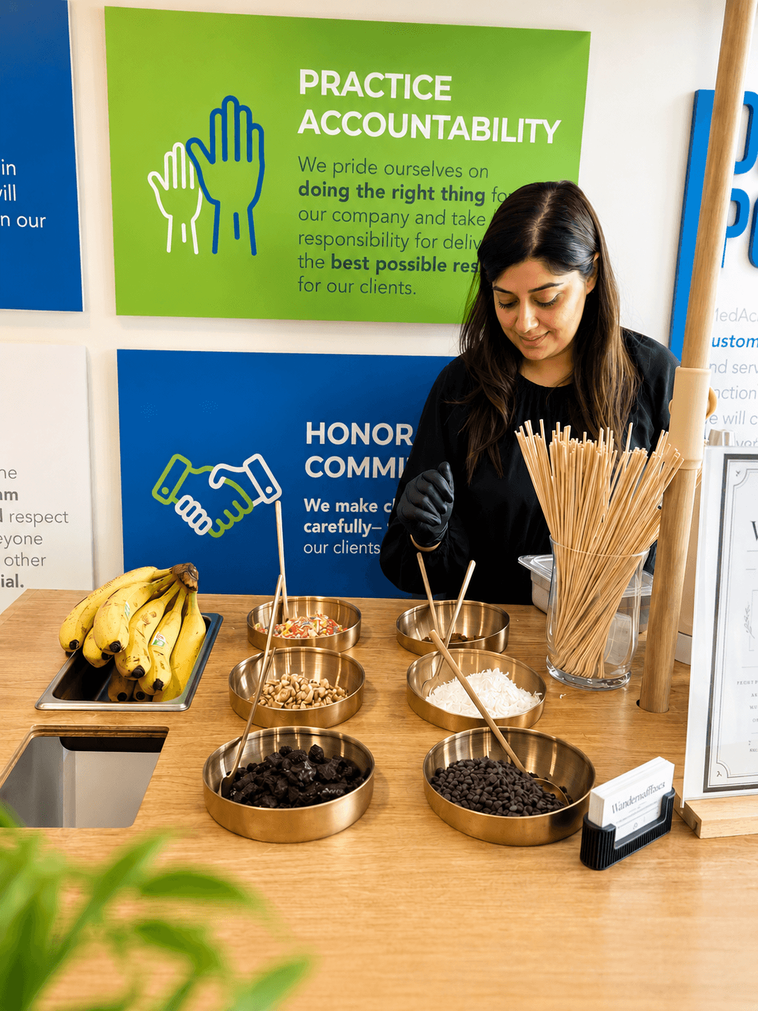 Anny serving made-to-order waffles from the Wander Waffles CO cart at a corporate event